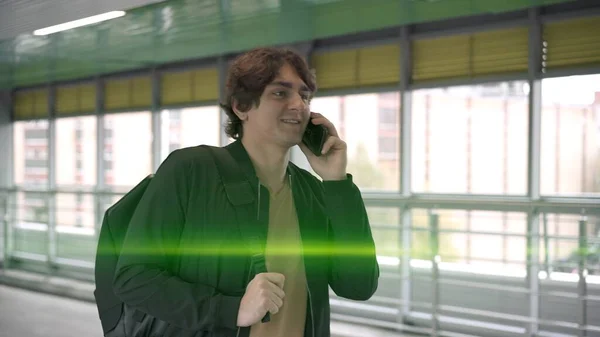 Jovem homem alegre com telefone na mão, no aeroporto dentro de lentes de sinalização — Fotografia de Stock