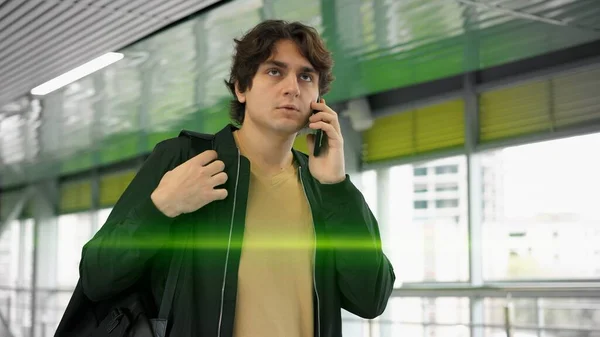 Jovem homem sério com telefone na mão, no aeroporto dentro de lentes de sinalização — Fotografia de Stock