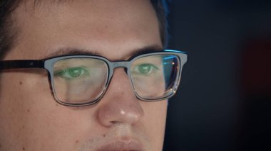 Gece geç saatlere kadar çalışıp bilgisayarın ekranına bakan bir adam.