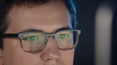 Gece geç saatlere kadar çalışıp bilgisayarın ekranına bakan bir adam.