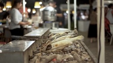 Şişte kızartılmış balığın el kamerası, sokak yemekleri pazarı.
