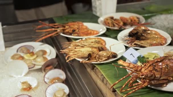 Handheld shot of crayfish and lobster grill on plates at street food market — Stock Video
