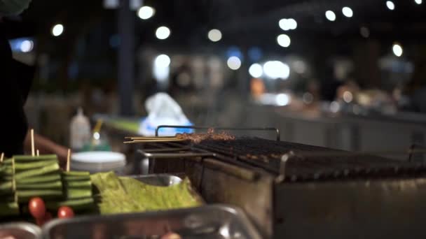 Coup de main de retourner sur la viande sur les bâtons sur le gril — Video