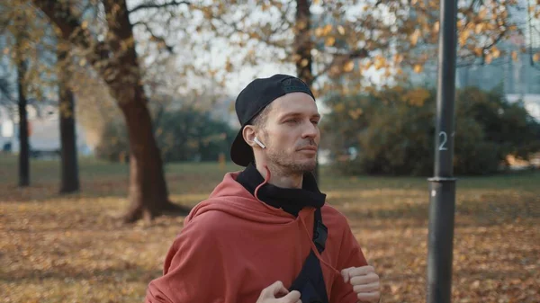 Hombre corredor en ropa deportiva en el parque de otoño en la ciudad, jogging concepto — Foto de Stock