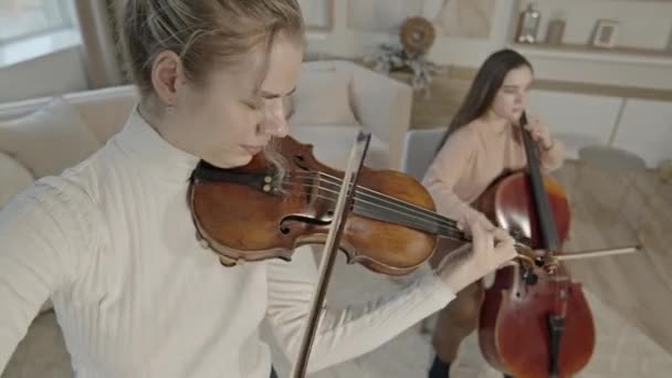 String duo de mulheres tocando violino e violoncelo em casa de luxo interior — Vídeo de Stock