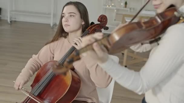 String duo de mulheres tocando violino e violoncelo em casa de luxo interior — Vídeo de Stock