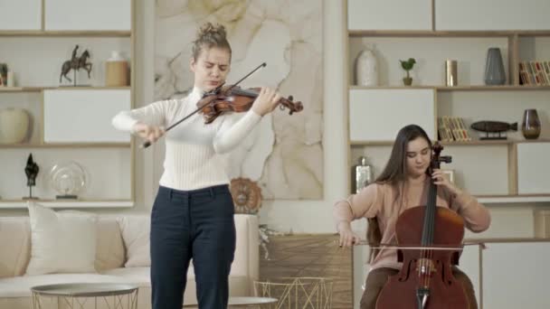 String duo de mulheres tocando violino e violoncelo em casa de luxo interior — Vídeo de Stock