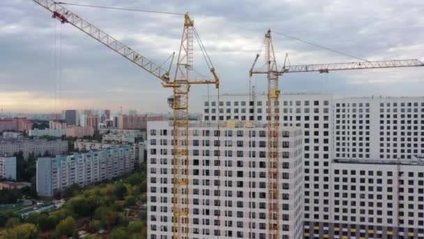 Guindastes de construção, casas de apartamentos residenciais em construção, zoom drone em — Vídeo de Stock