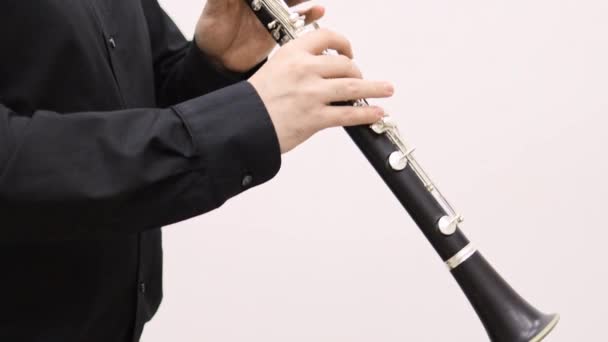 Férfi fekete ing játszik klarinét álló fehér háttér