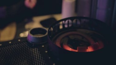 Eller maşayla nargile kasesine kömür atıyor.