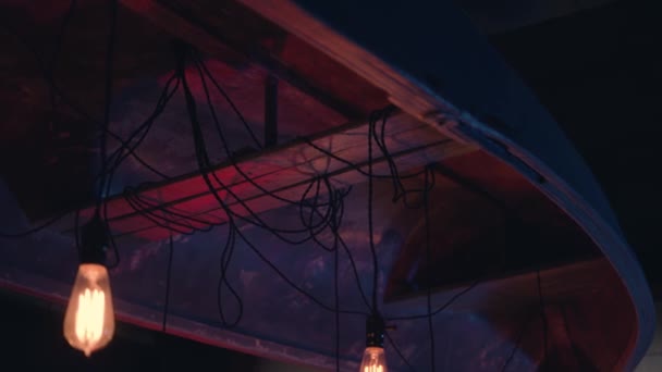 暗闇の中で天井から吊るされた黄色のヴィンテージランプ — ストック動画