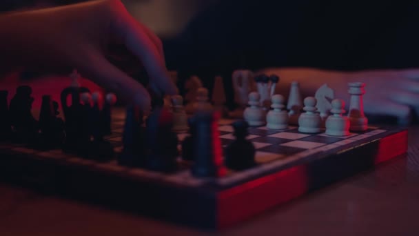 Manos masculinas y femeninas jugando al ajedrez en el bar interior — Vídeo de stock