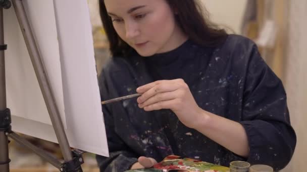 Młoda kobieta malarka z sztalugami pracująca w pracowni sztuki nowoczesnej — Wideo stockowe