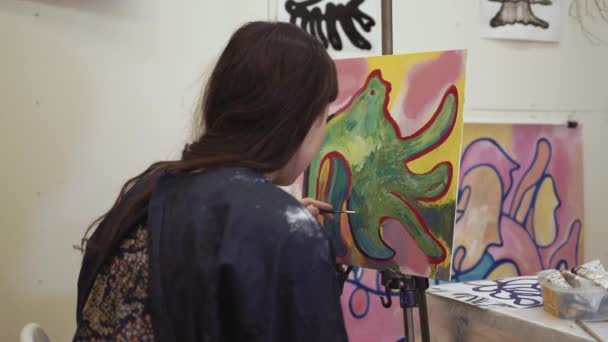 Kobieta artystka z sztalugi gospodarstwa pędzel sztuki malarstwo w jasnym świetle studio sztuki — Wideo stockowe