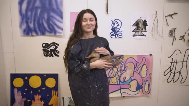 Pittore artista donna sorridente in piedi in studio con immagini sulla parete — Video Stock