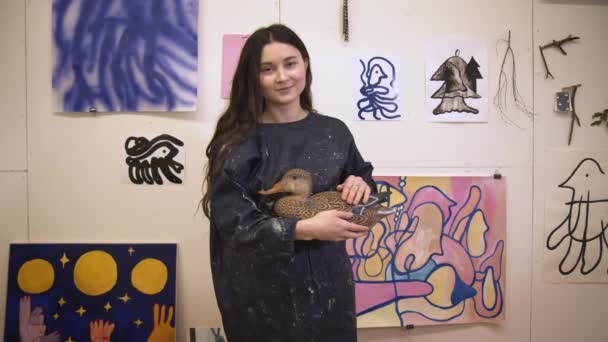Artista feminina pintora sorrindo de pé em estúdio com fotos na parede — Vídeo de Stock