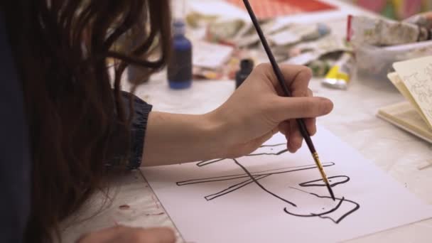 Vrouw met een kunstpenseel op wit papier in kunststudio — Stockvideo
