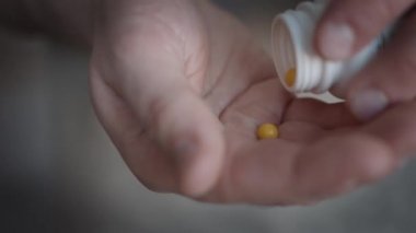 Küçük haplarla dolu bir erkek eli