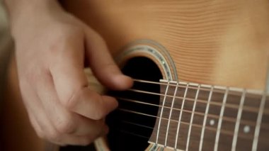 Hafif akustik gitar çalan müzisyen parmakları