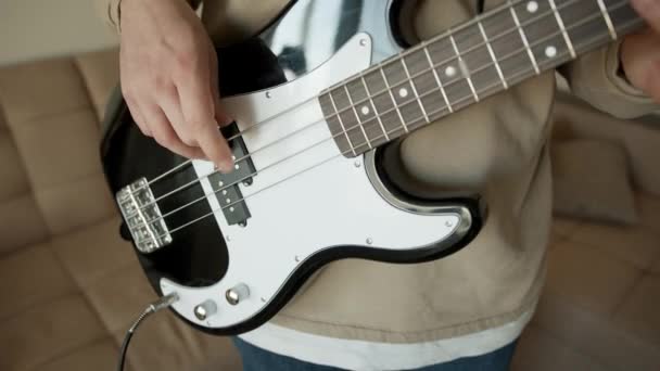 Muzyk z gitarą basową w rękach w domu — Wideo stockowe