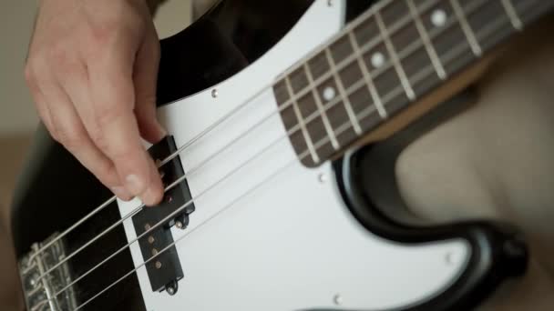 Muzyk z gitarą basową w rękach w domu — Wideo stockowe