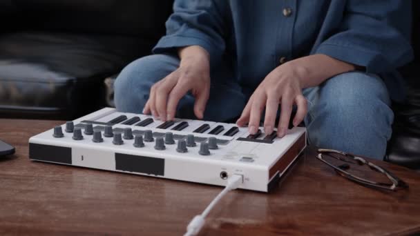 Жінка пальцями грає акорди і мелодії на клавіатурі, виробництво музики — стокове відео