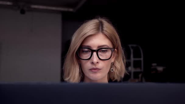 Σοβαρή γυναίκα με αυτοπεποίθηση εμφάνιση, που εργάζονται χρησιμοποιώντας φορητό υπολογιστή στο σπίτι — Αρχείο Βίντεο