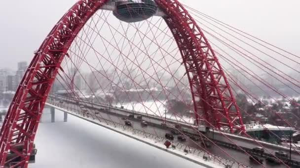 Aerial left to right panorama shot of red bridge with busy traffic in Moscow area winter cityscape — Stock Video