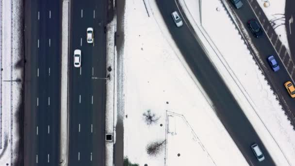 トップビューのドローンの大きな道路の接合部のショットは、多くの車のマルチレーンの道路上で移動する。カメラが進む。冬時間 — ストック動画