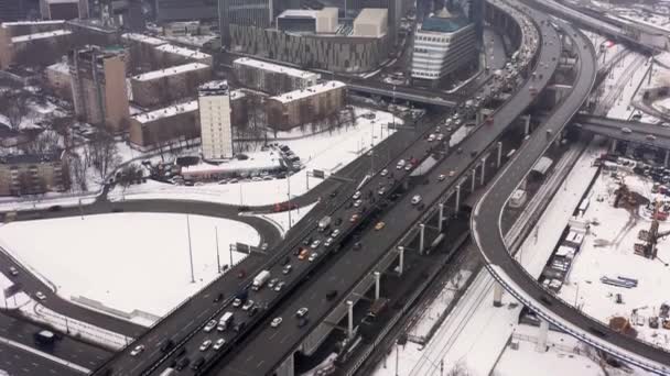 Inclinado hacia arriba disparado desde la carretera de tráfico ocupado hacia los edificios del centro de negocios de la ciudad de Moscú en invierno — Vídeo de stock