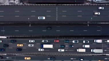 Büyük bir yolun insansız hava aracı görüntüsü, birçok araba çok şeritli yolda ilerliyor. Kamera sağa gidiyor.