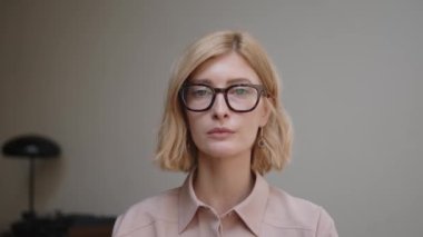 Kendine güveni olan ciddi bir kadın, kameraya doğru bakıyor.