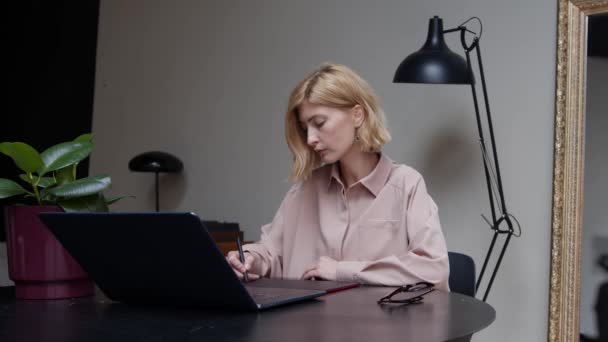 Grafikerin arbeitet mit Tablet und Laptop im Büro — Stockvideo