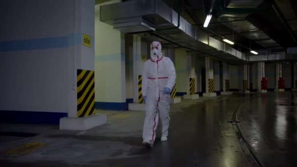 Adam doktor yeraltı otoparkında tehlikeli madde kıyafeti içinde yürüyor. — Stok video