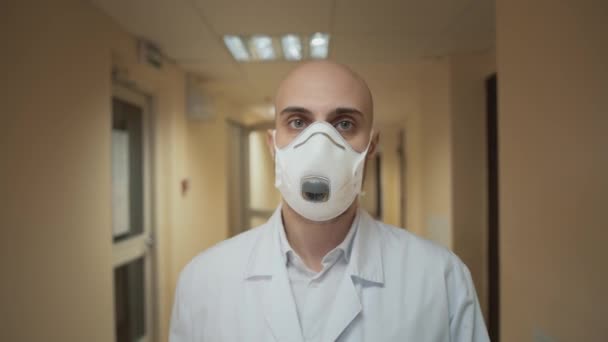 Mann mit Maske läuft auf langem Flur im Krankenhaus — Stockvideo