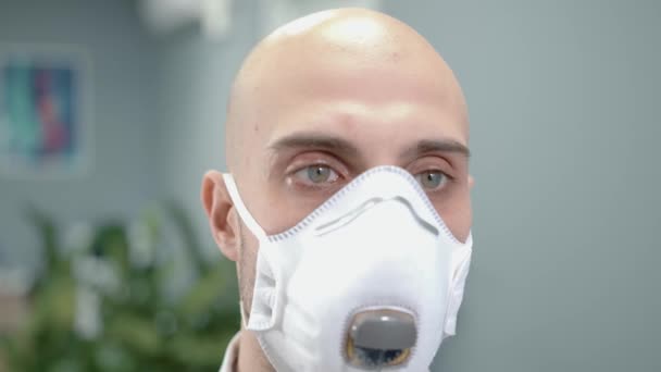 Человек врач в маске портрет на размытом фоне больницы — стоковое видео