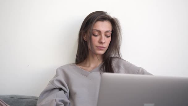 Jovem mulher trabalhando com laptop no interior da sala de estar luz — Vídeo de Stock