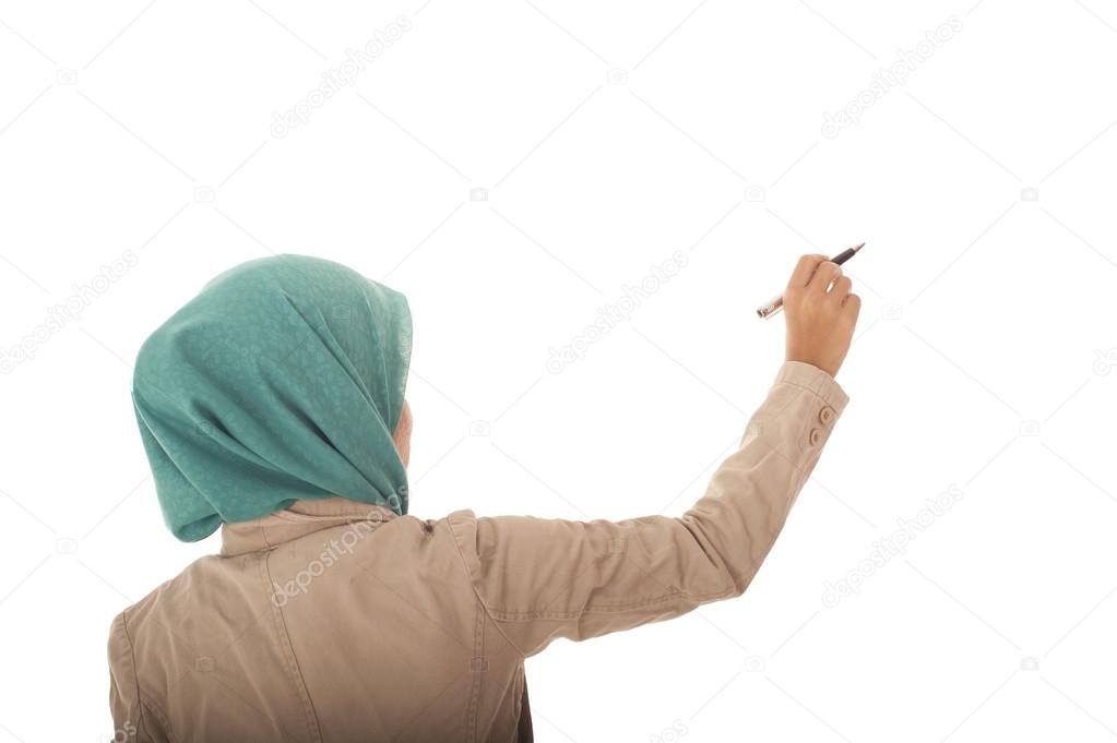 Muslimah woman writing on blank wall.