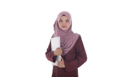 Genç çekici muslimah işkadını bir laptop tutar.