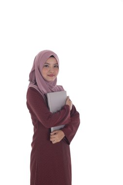 Genç çekici muslimah işkadını bir laptop tutar.