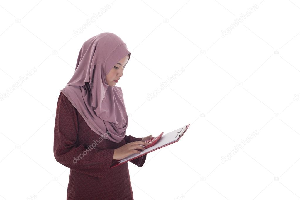 Attractive young muslimah businesswoman calculating her expandit