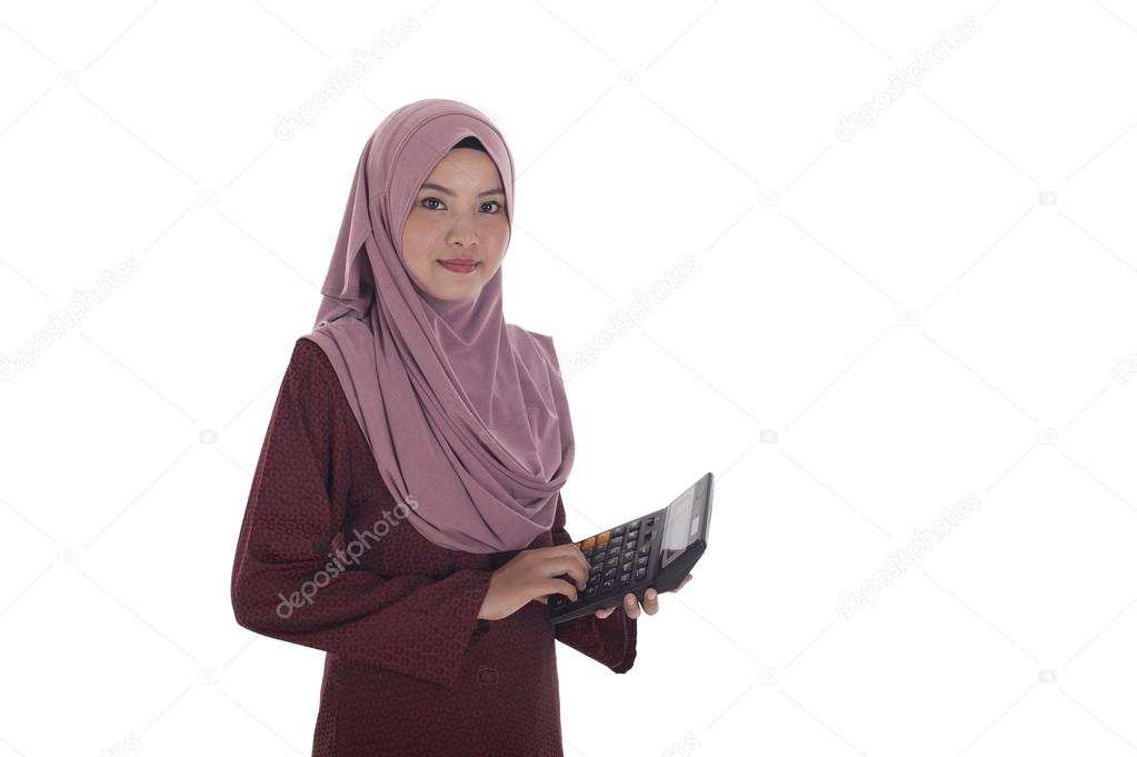Attractive young muslimah businesswoman holding a calculator.