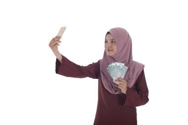 Kendi kendine potrait çekerken dolar tutan gülümseyen bir Müslüman kadın