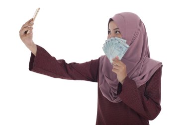 Kendi kendine potrait çekerken dolar tutan gülümseyen bir Müslüman kadın