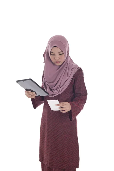 Молодая мусульманка читает расписку . — стоковое фото