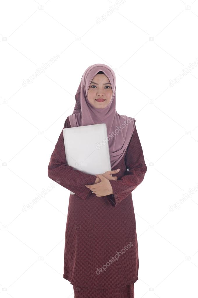 Young attractive muslimah businesswoman holds a laptop.