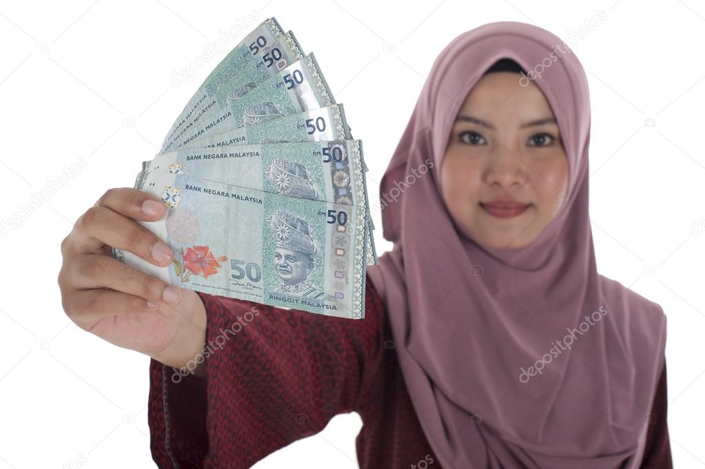 A smiling muslim woman holding a bunch of Malaysian Ringgit, iso
