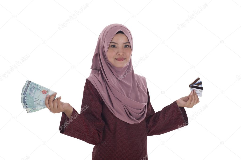 A smiling muslim woman holding a bunch of Malaysian Ringgit and 