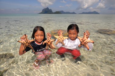Semporna, Malezya - 6 Mart 2015: tanımlanamayan bajau kızlar starfishes Semporna, Malezya yakalamak. Bajau bazen 