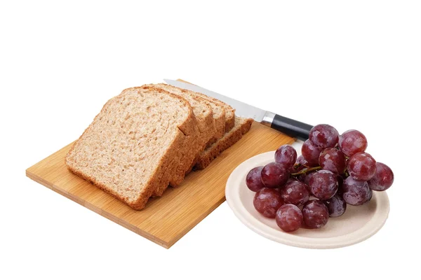 Pão de grão inteiro e uvas isoladas sobre fundo branco — Fotografia de Stock